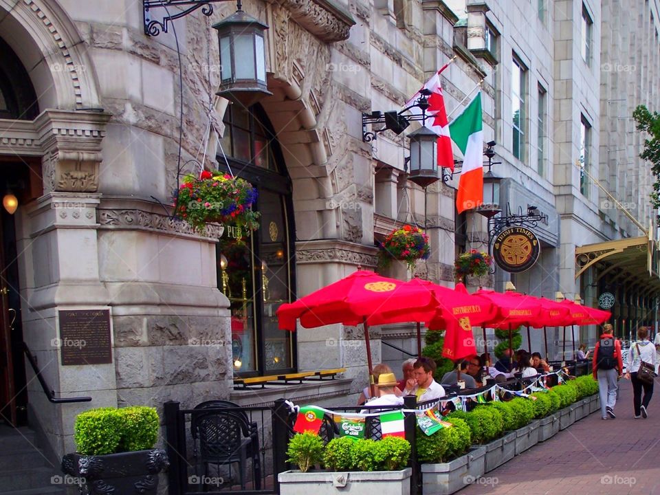 Outdoor cafe in British Columbia, Canada, red umbrellas, stonework, flags, Victoria 