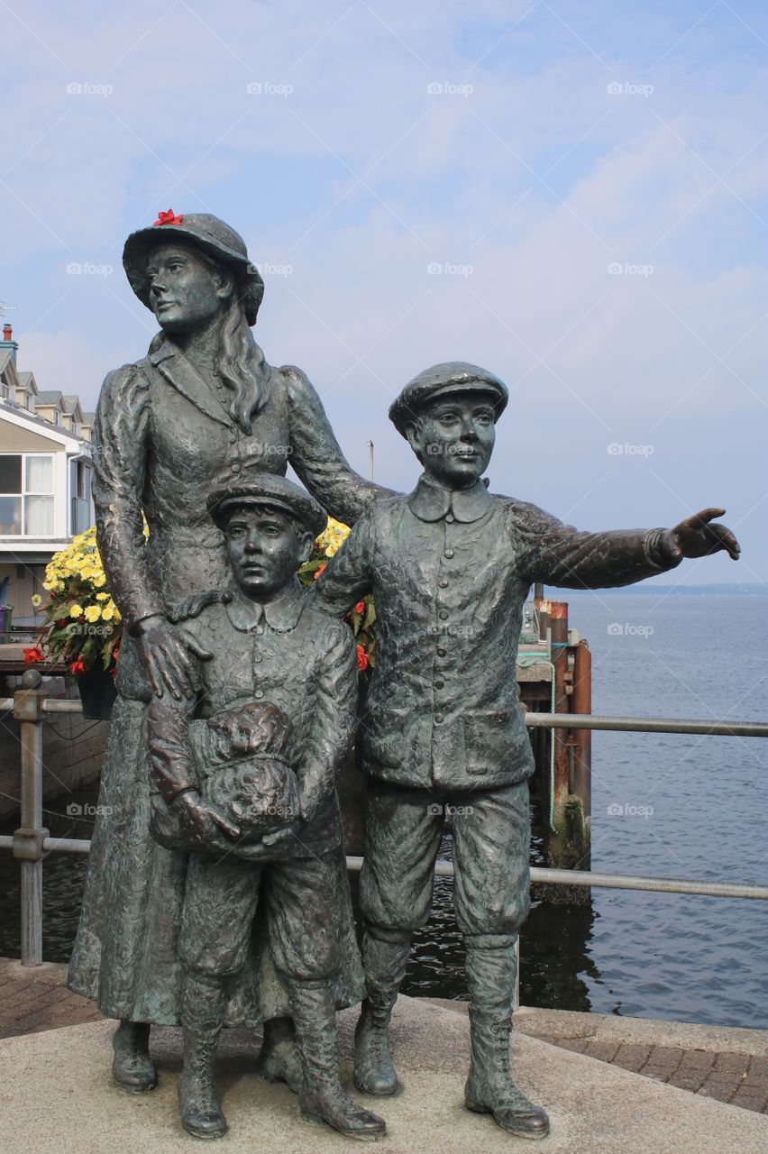 Statue of Annie Moore and her brothers on the quayside in Cobh, Ireland