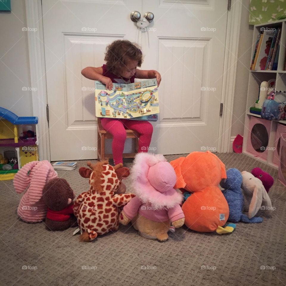 Playing School. A toddler girl playing school with her stuffed animals.