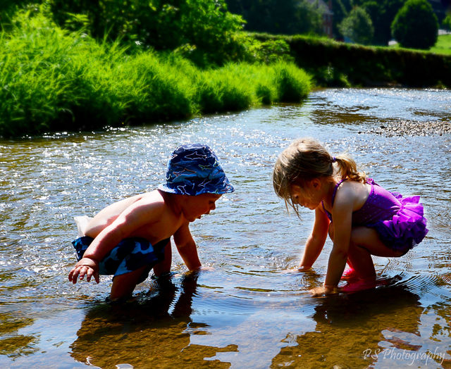 siblings playing in creek