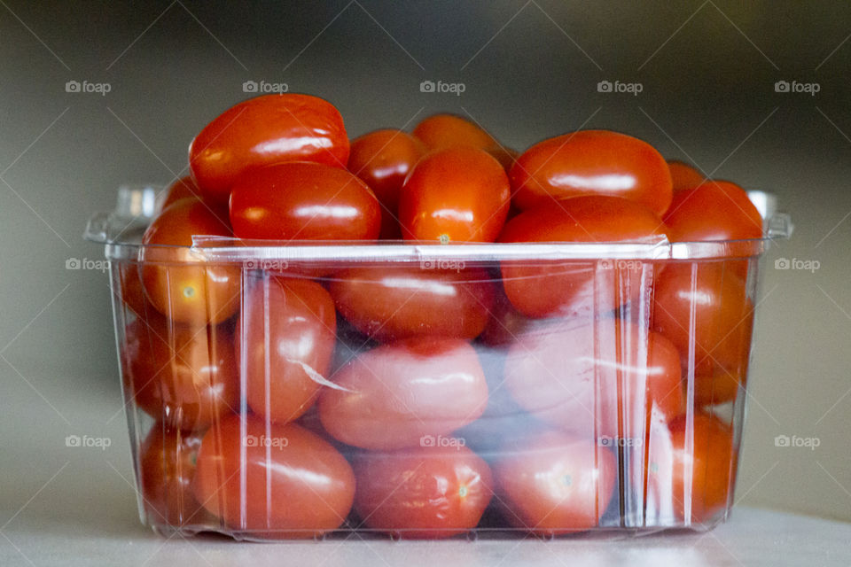 Red mini tomatoes in a plastic box 