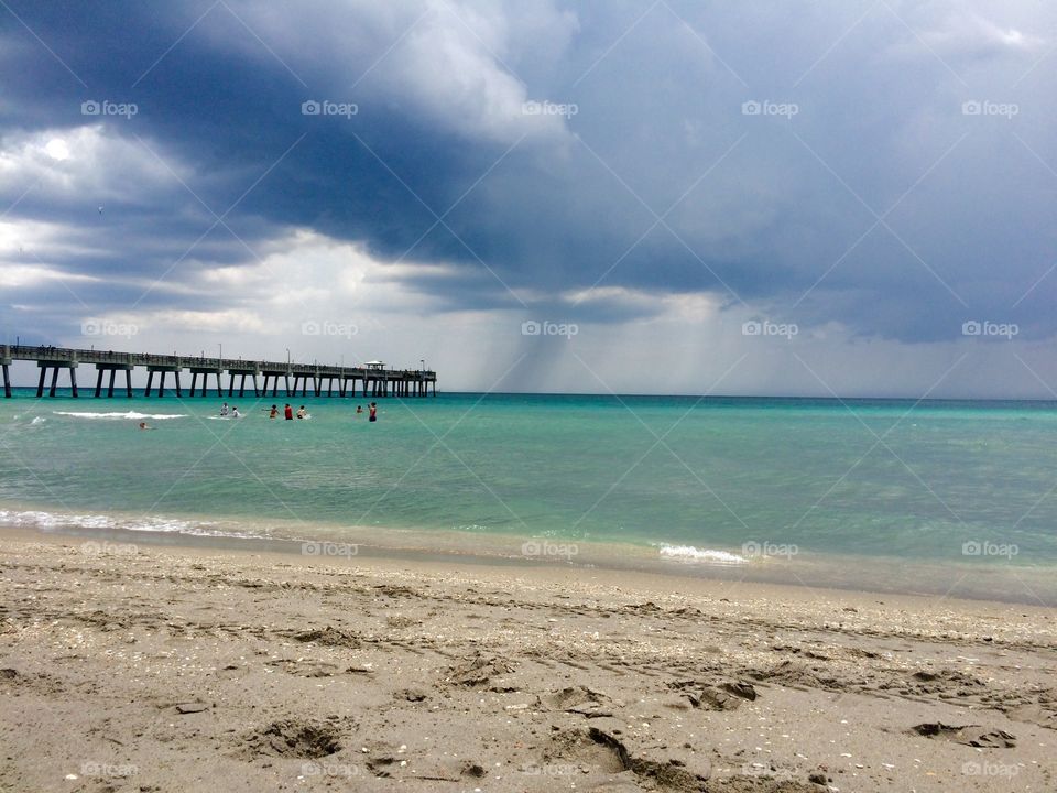 Scenic view of beach against storm cloud