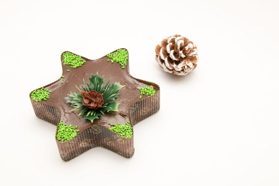 Composition Of Christmas Star Chocolate Muffin Cupcake And  Pine Cone Isolated On White Background

