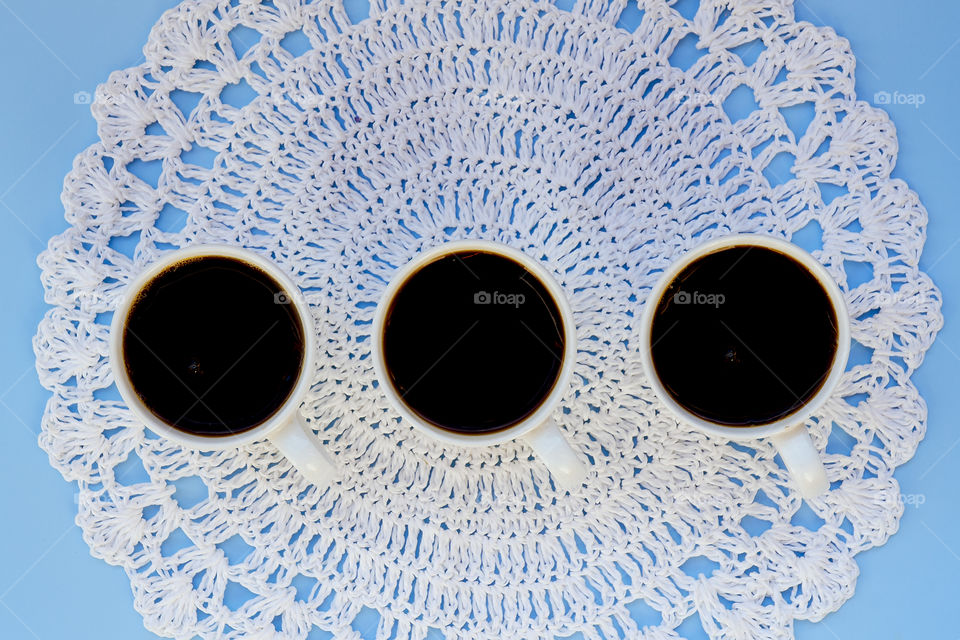 Business working morning with cup of hot coffee, fresh delicious croissant on blue background close up. Top view, copy space, flat lay, mockup.