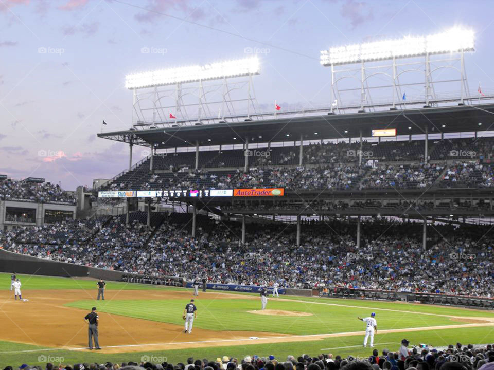 Wrigley Field at sunset. pink and purple clouds line the sky above Wrigley Field in Chicago, IL