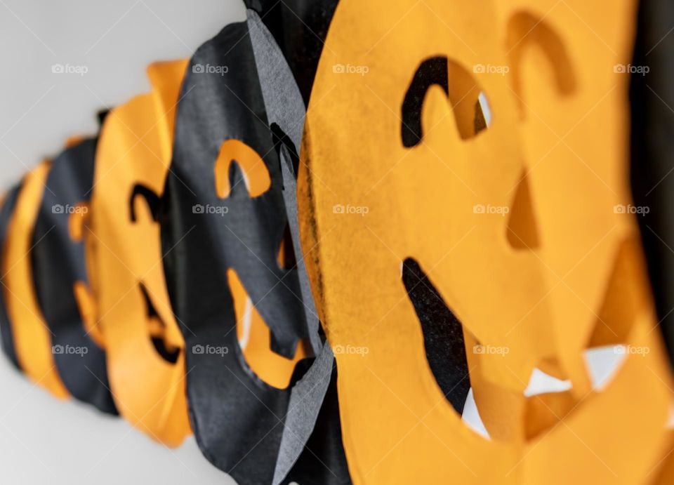 A paper chain of orange and black pumpkin faces 