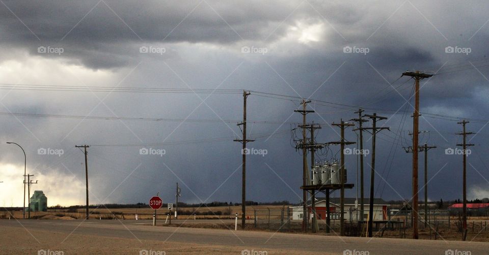 power substation transformers intersection with storm clouds covered sky