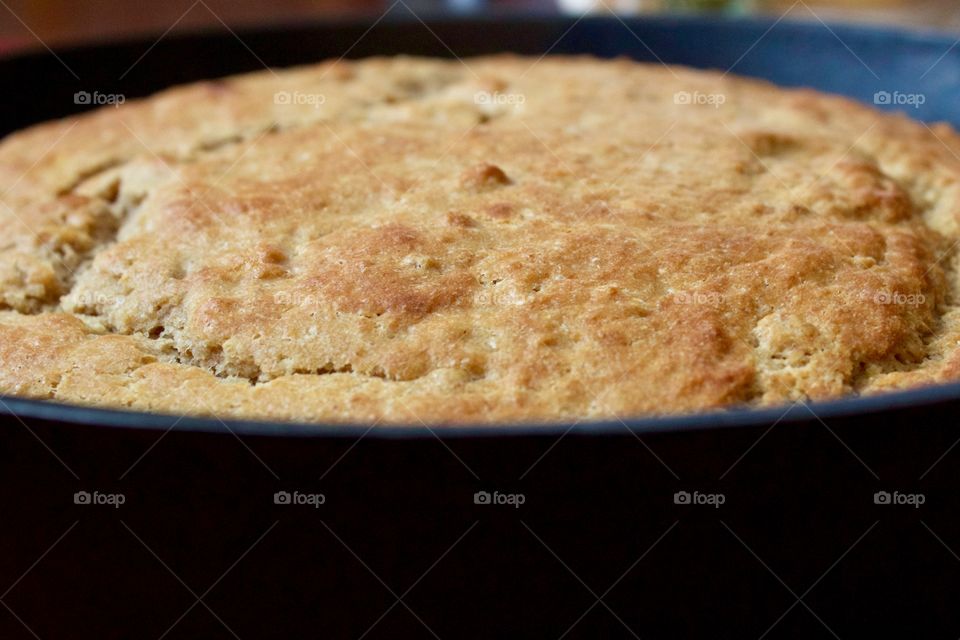 Closeup of freshly baked sourdough cornbread in a cast iron skillet