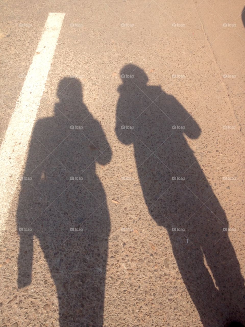 Two shadows on the asphalt