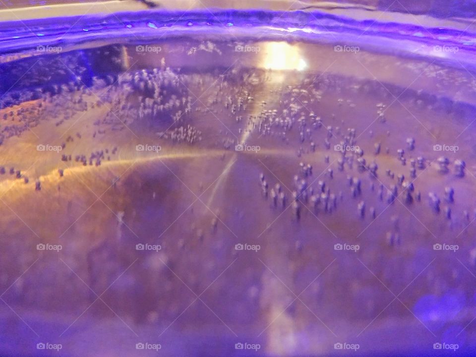 Water boiling in lit glass kettle close up