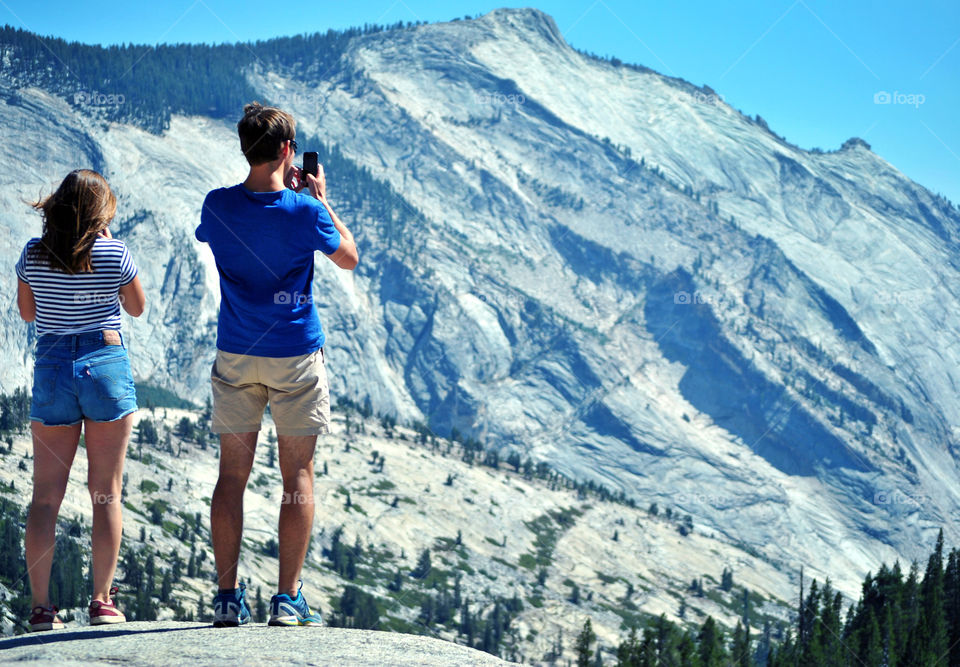 Traveller taking a photo of the view at Olmsted Point, Yosemite