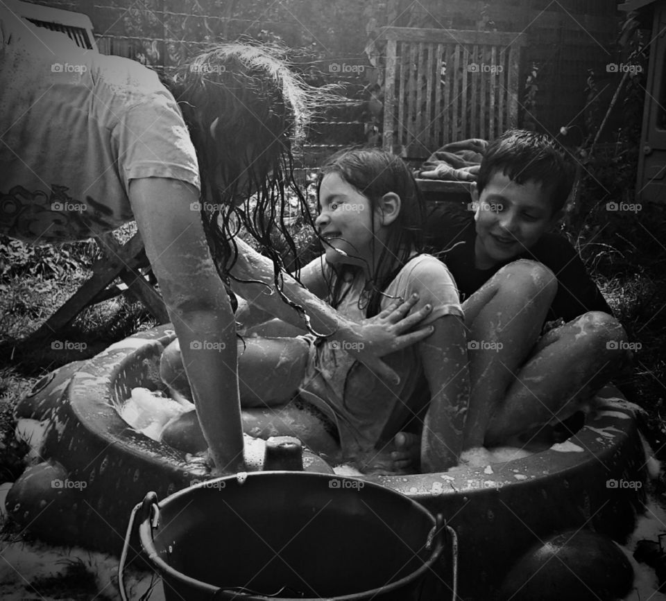 My children playing in the garden in the water in the summer