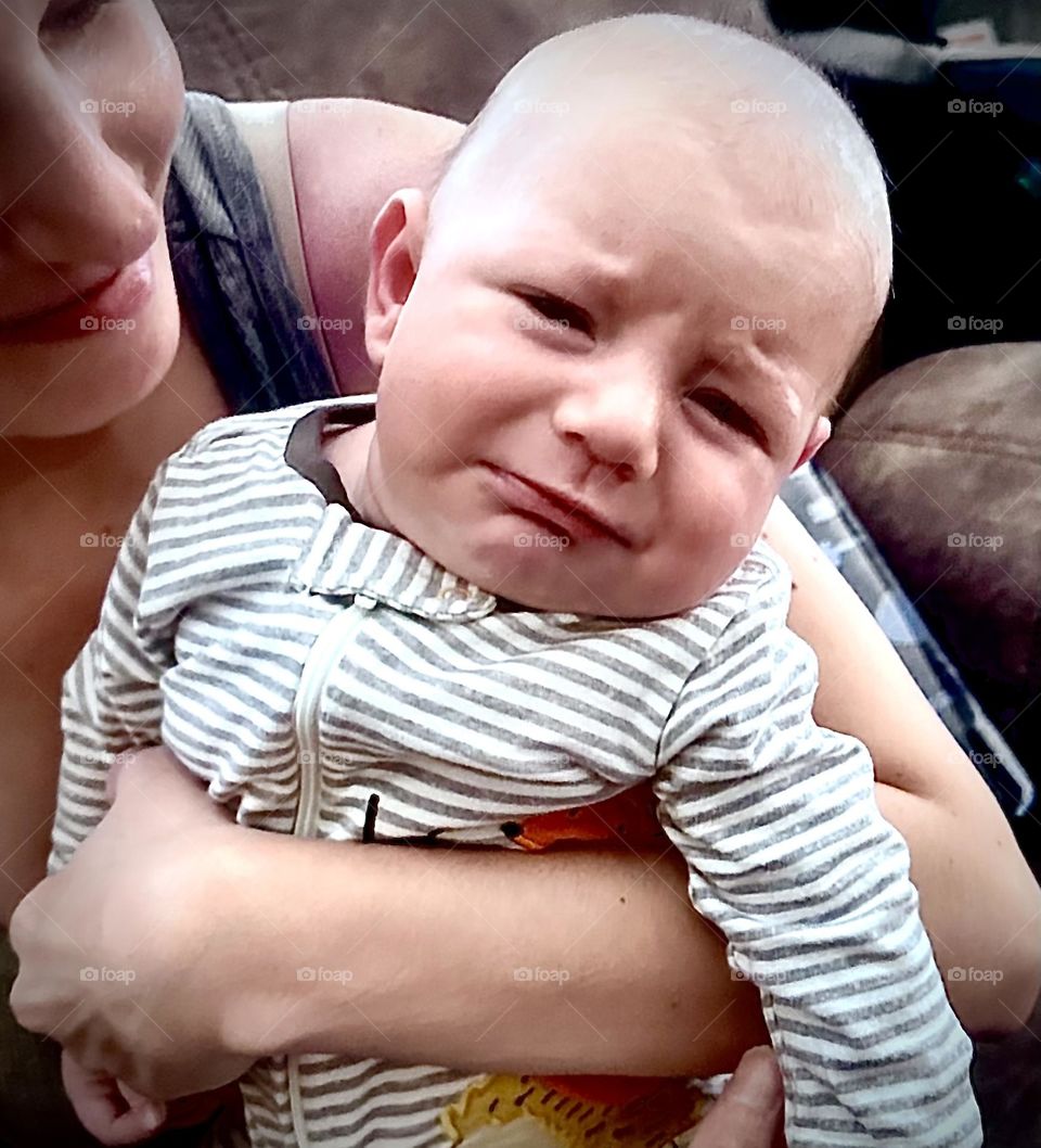 Baby crying while being held.
