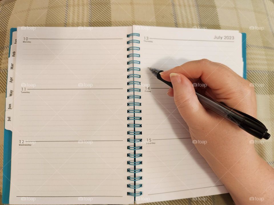 keeping track of your days, thoughts, and schedules by writing in a day planner book