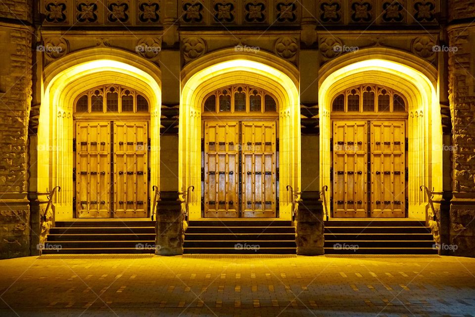 Three doors illuminated  wooden portal and stairs
