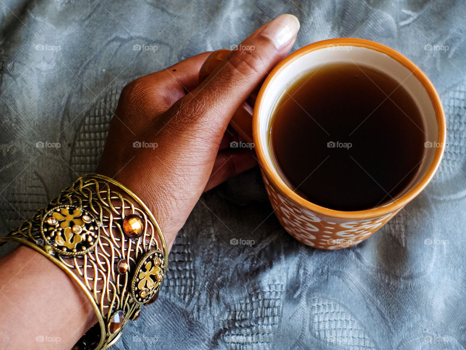 Hand holding a cup of tea.