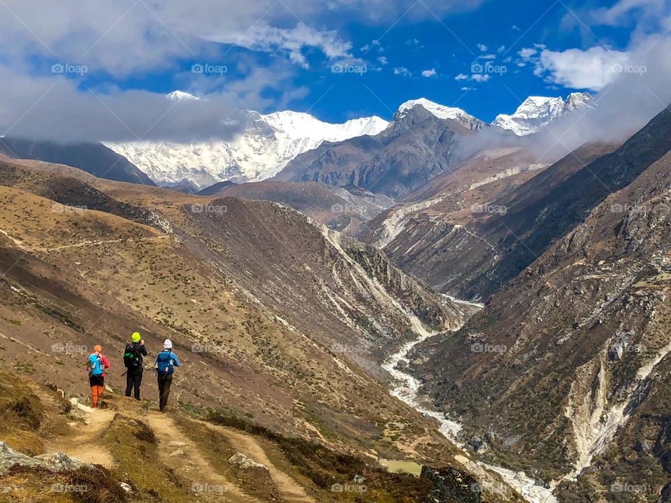 Hiking with a group of friends through the amazing Himalayan mountains and pausing to admire the view