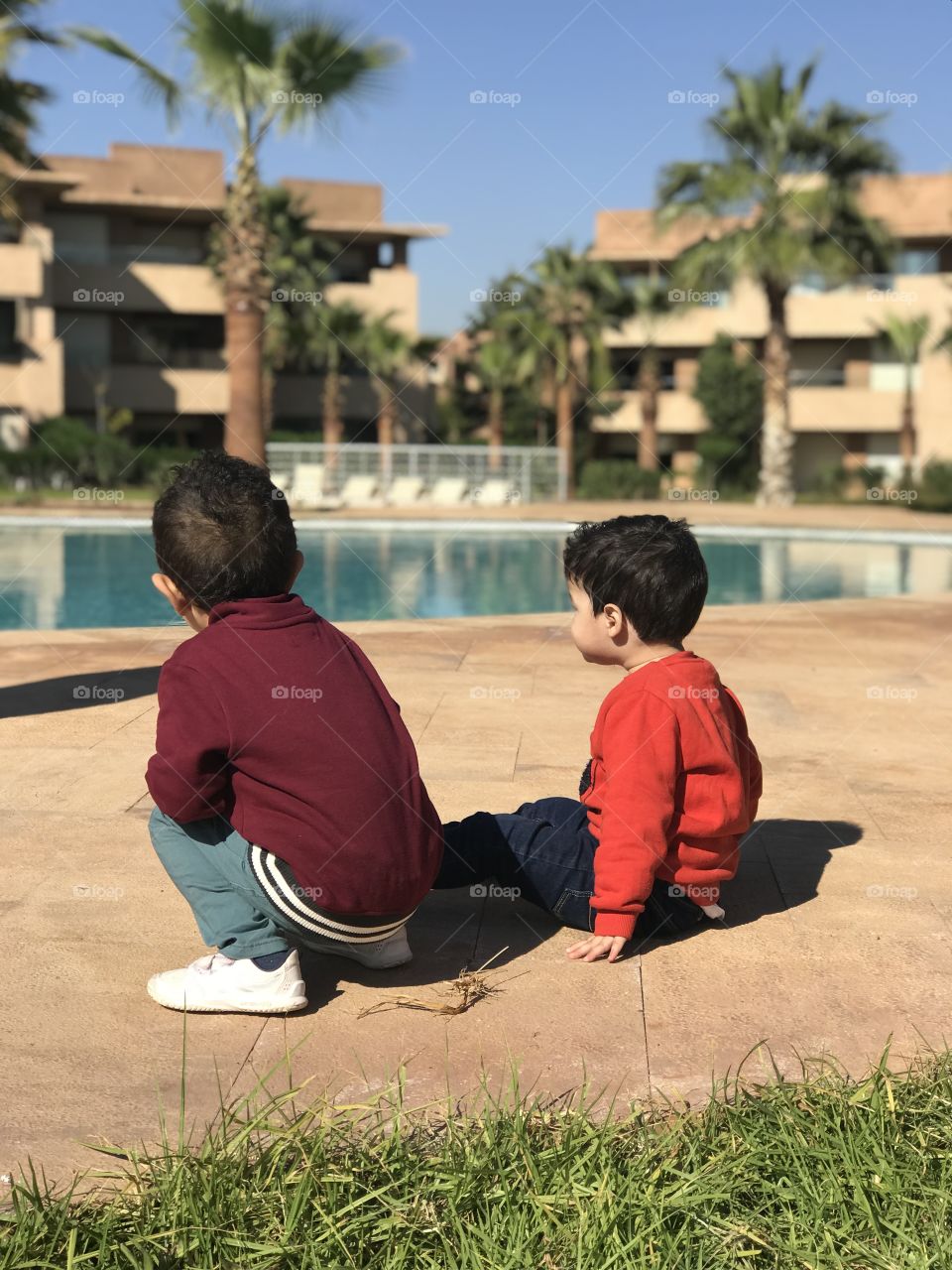 Kids playing front of the swimming pool 