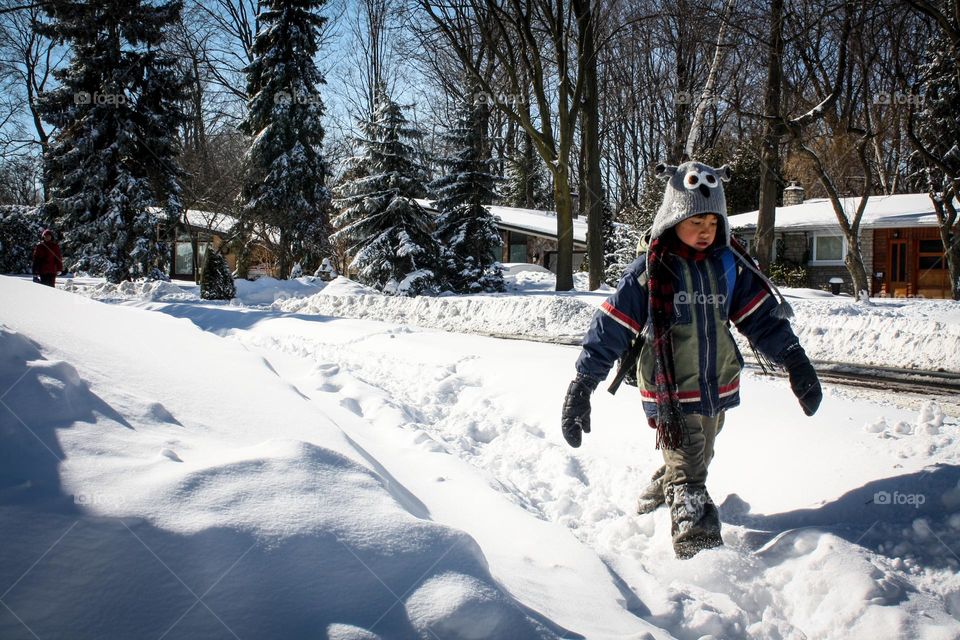 Cute little boy is walking in the snow