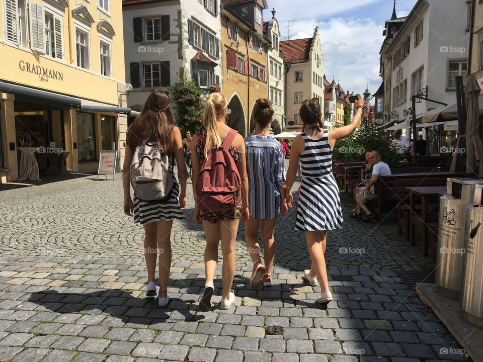 Teens chatting and walking in resort town Lindau, Germany.