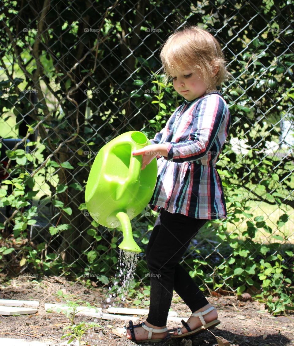 child watering garden