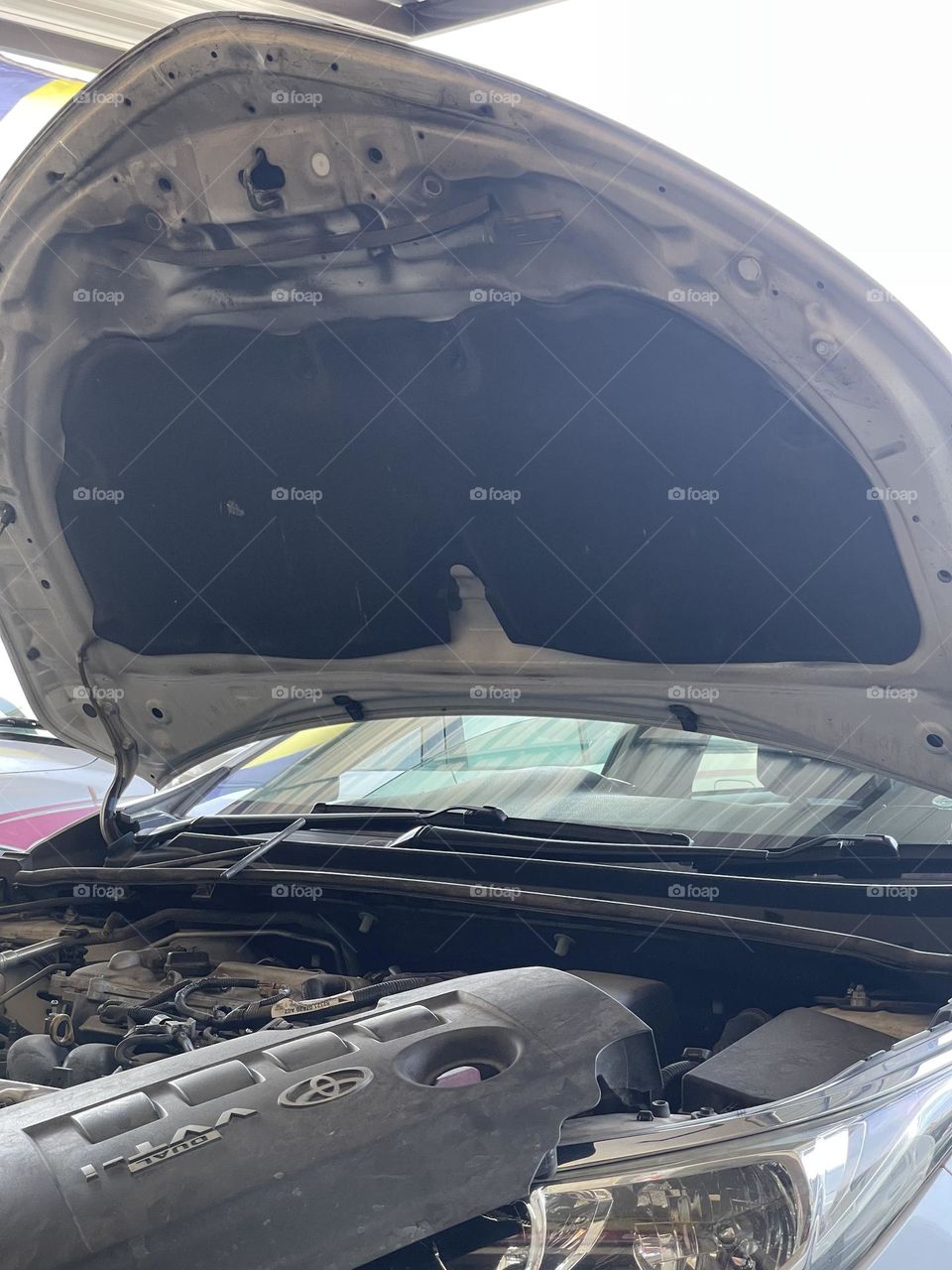 An open hood of a car for checking and fixing the engine 