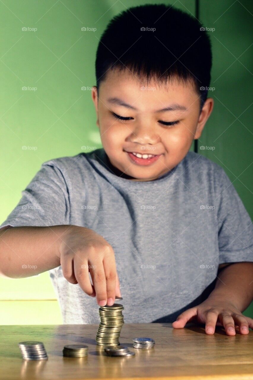 Little boy stacking coins