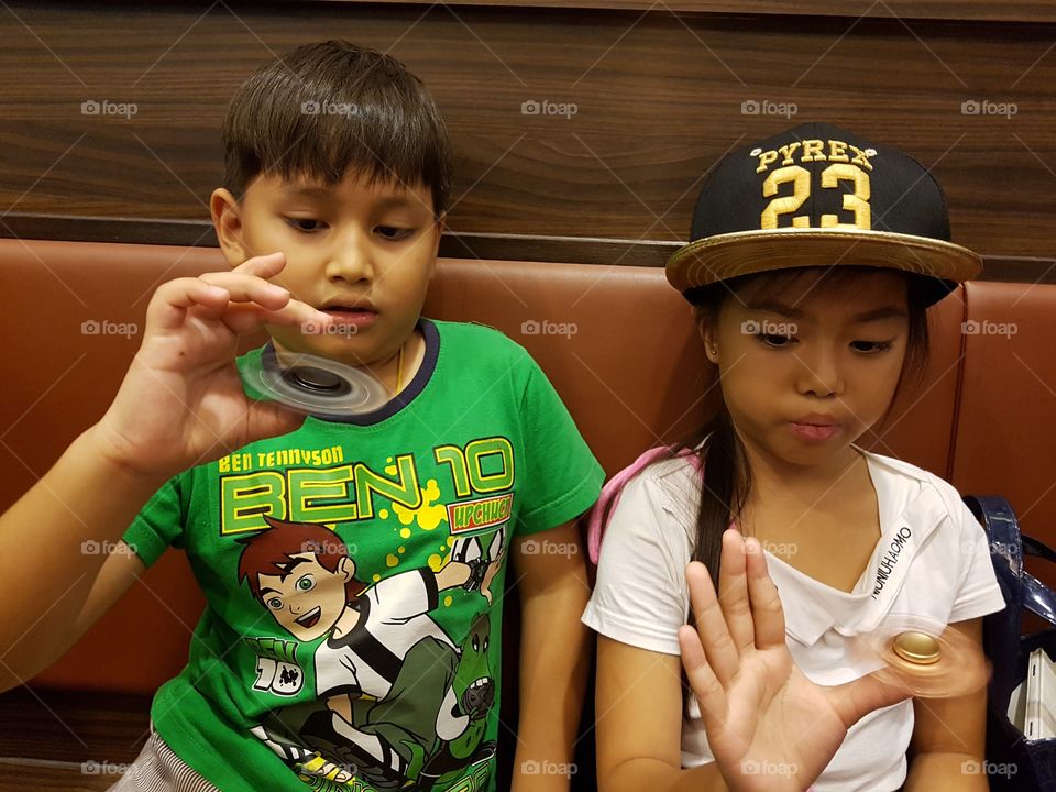 young boy and girl playing new finger toy spinner