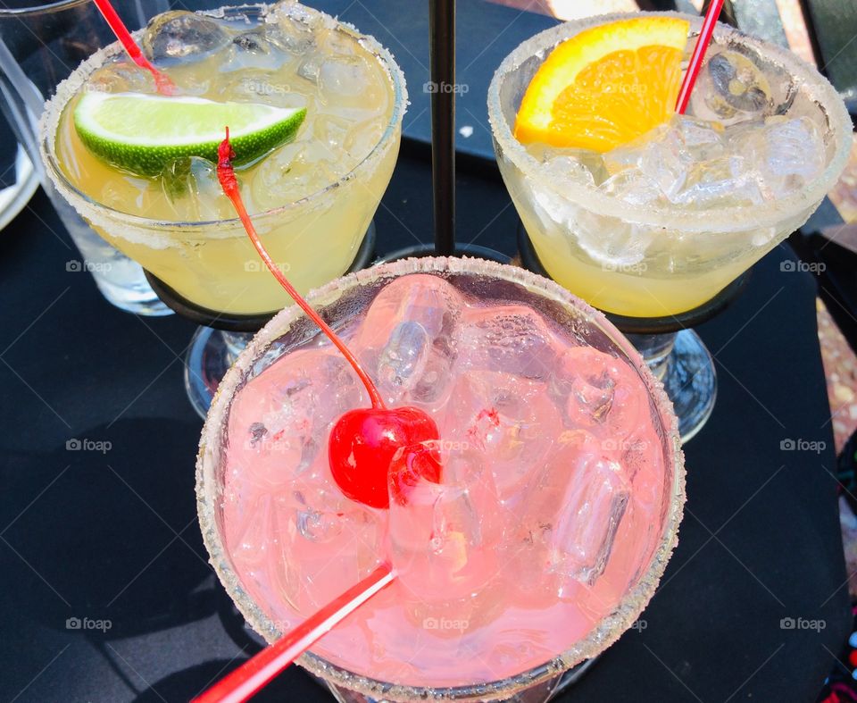 Triple margarita with cherry, lime, and orange garnish 