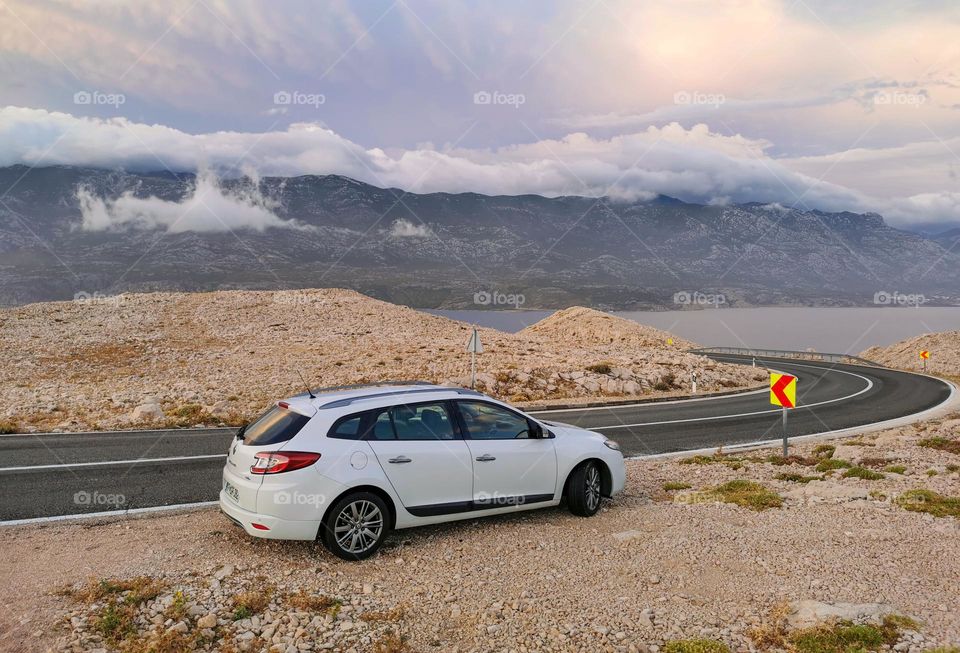 Car parked by the road through arid terrain on an island