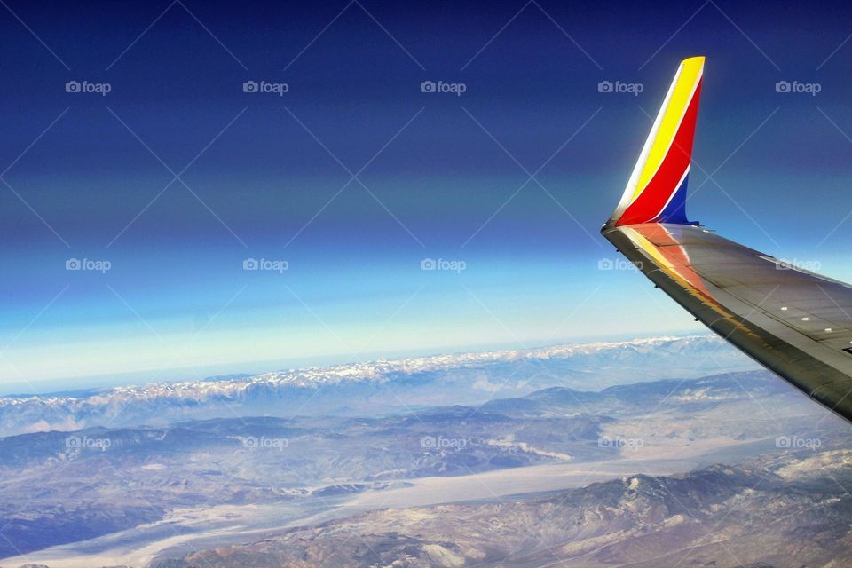 landscape, vacation View from an airplane. Blue Sky Horizon, land patterns, snow capped mountains