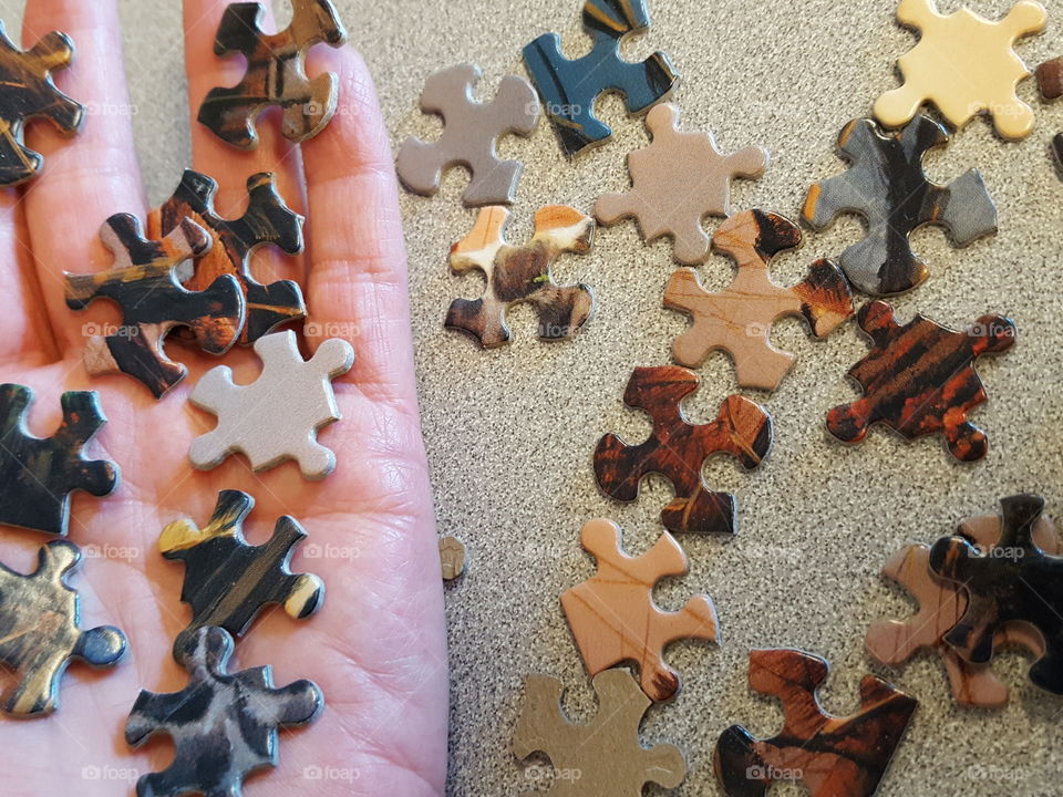 Puzzle pieces on human hand