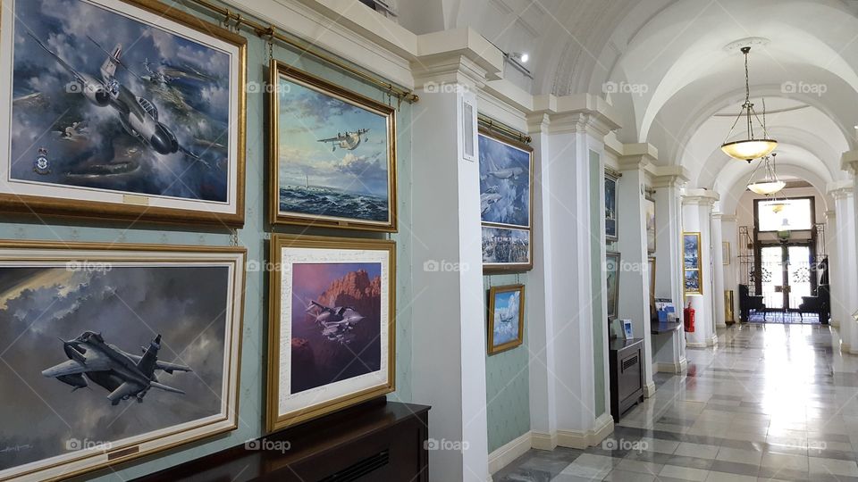 Military art works line the wall of a corridor in the RAF Club on Piccadilly, central London, UK