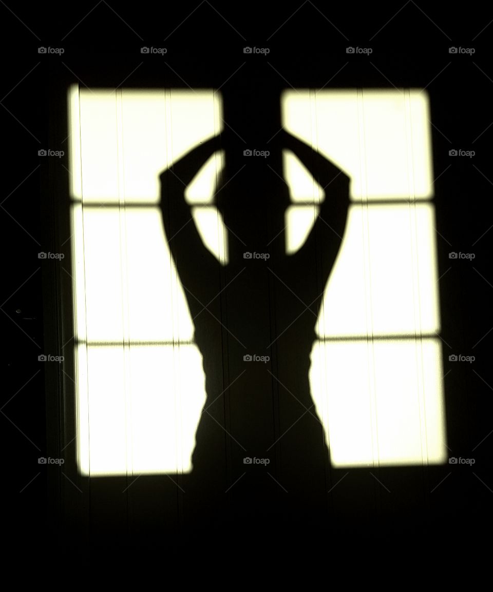 Silhouette of a woman against a window