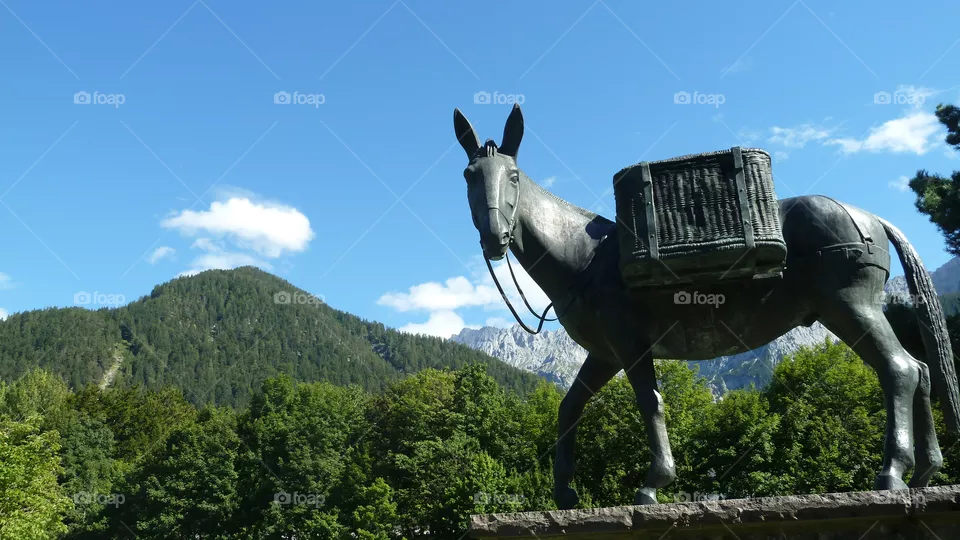 Maultiestatue, im Hintergrund die Alpen