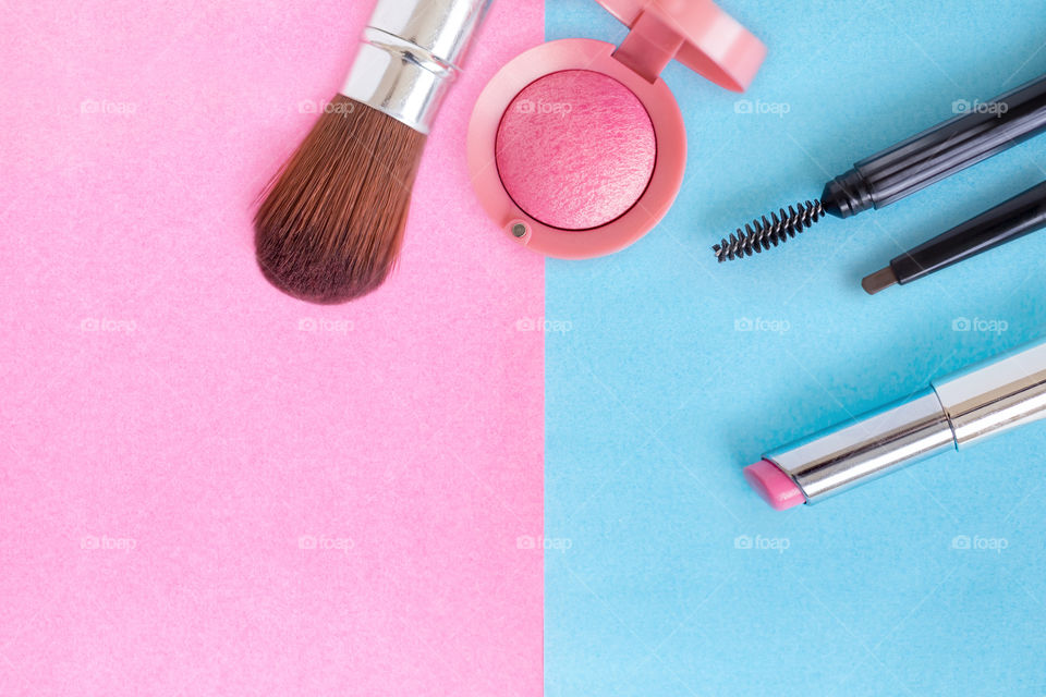 Essentials makeup on pink and blue background, top view, flatlay