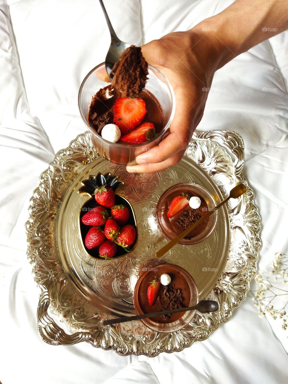 Homemade chocolat mousse with coconut cream exposed on beautiful glasses with pieces of strawberry.