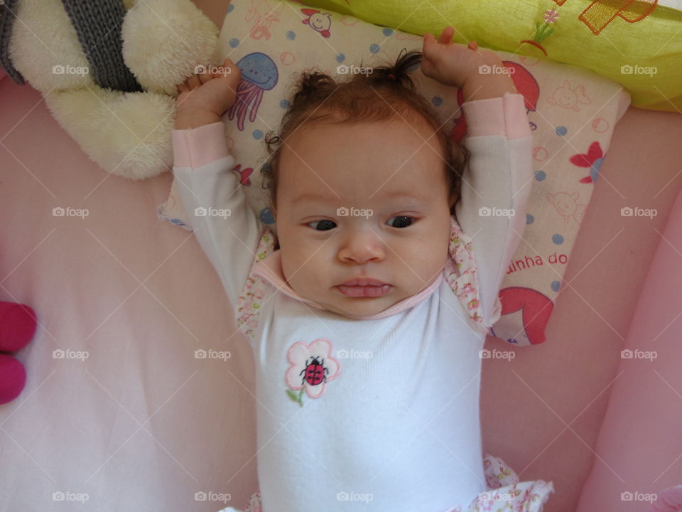 Baby lying stretching on bed