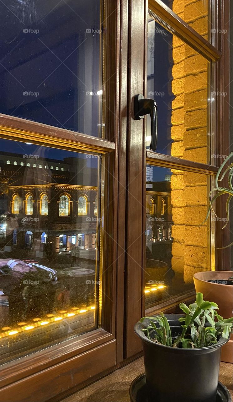 Golden evening lights shimmer through the iconic windows of Manufaktura in Łódź, capturing its historic charm and modern allure.