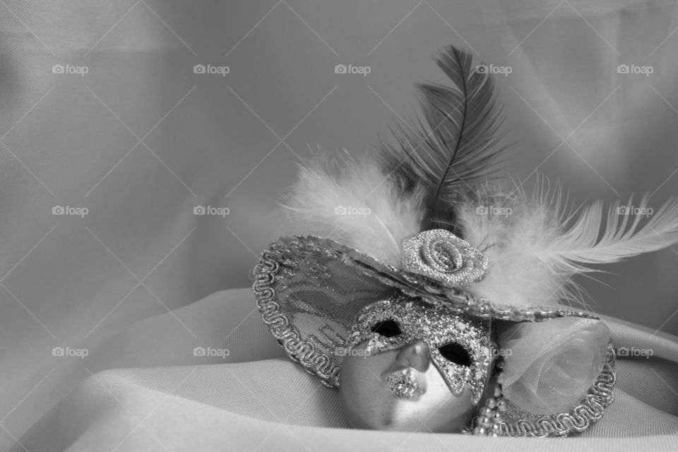 Black and white miniature decorative mask on top of textile material macro shot