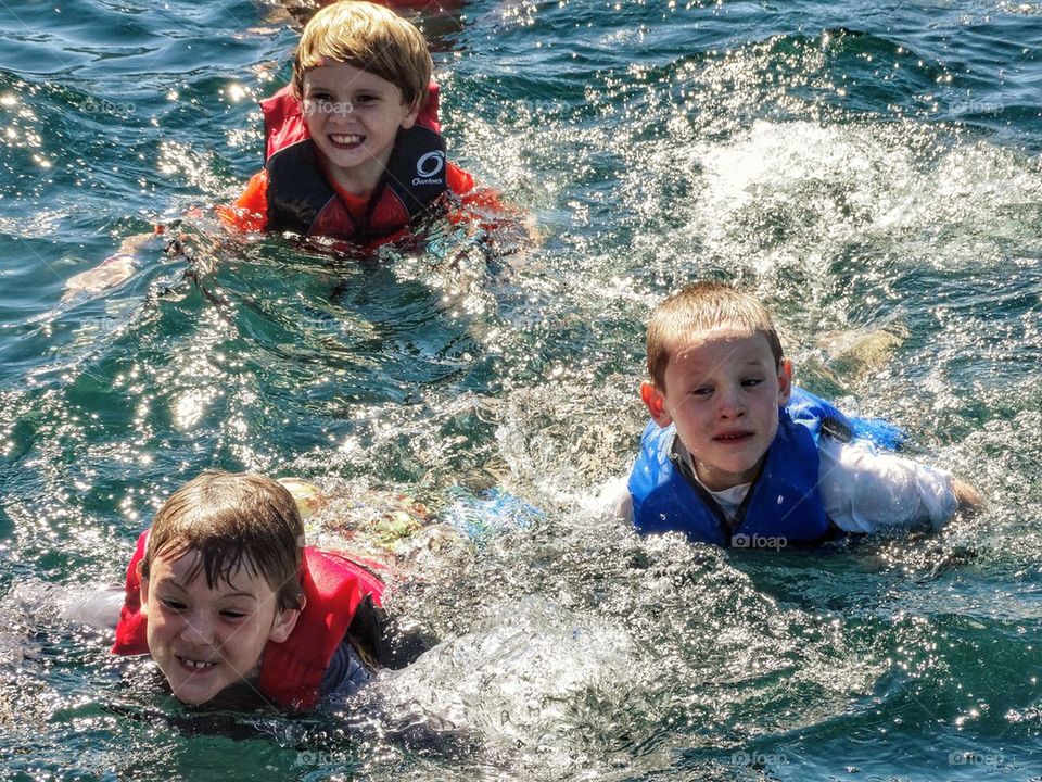 Water Safety. Children Wearing Life Vests In The Water
