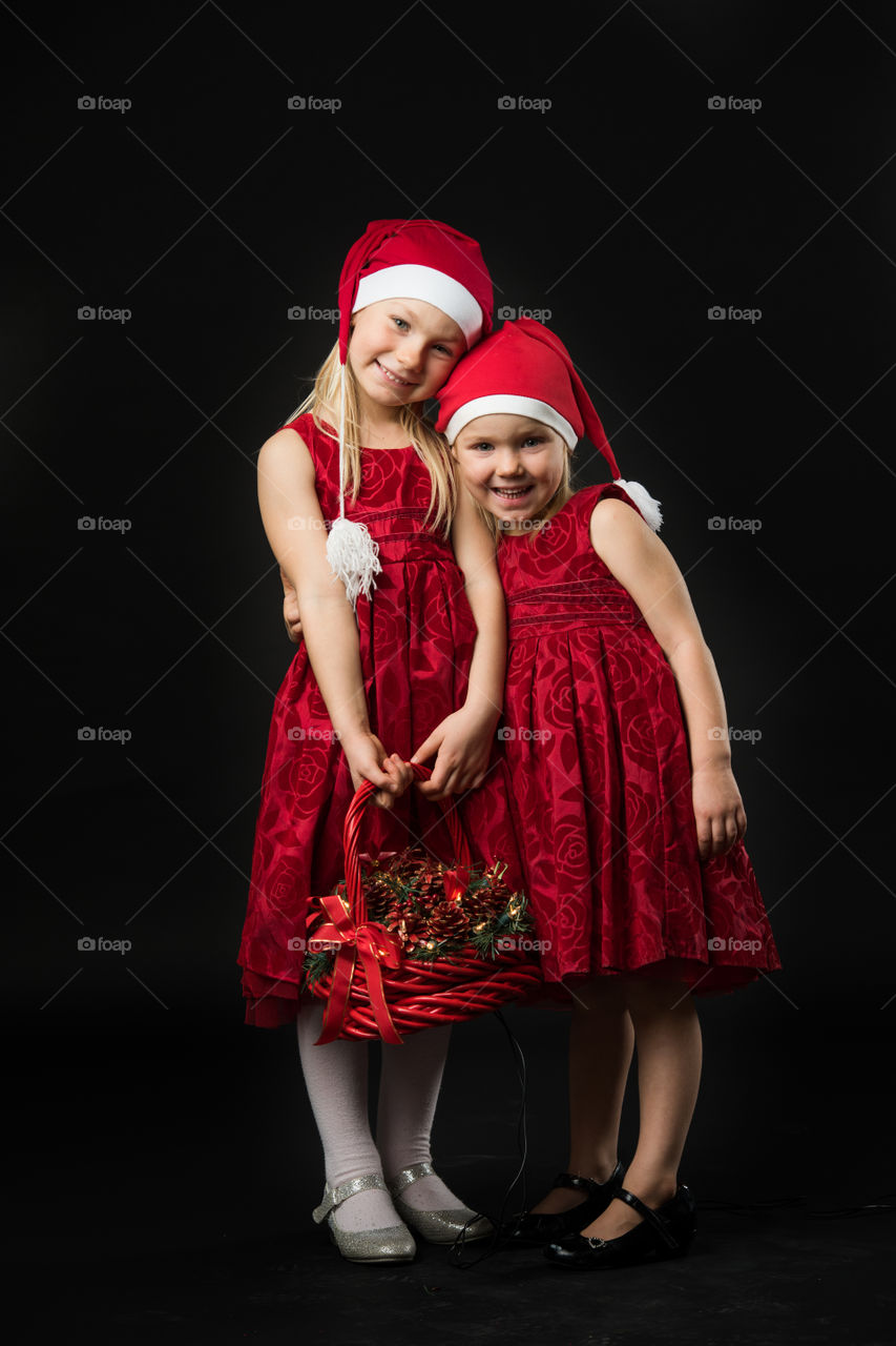 Two sisters posing for christmas portrait.