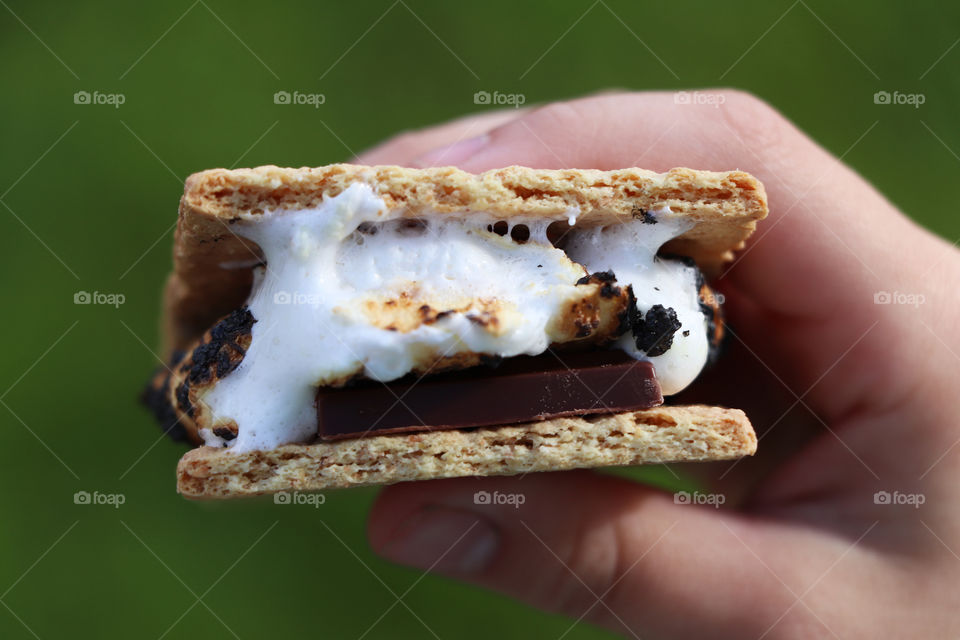 A child holding smores in their hand