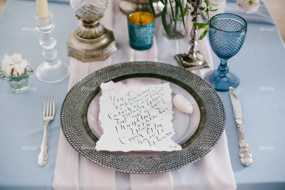 Graphic arts of beautiful wedding calligraphy cards and silver plate on festive wedding table. 