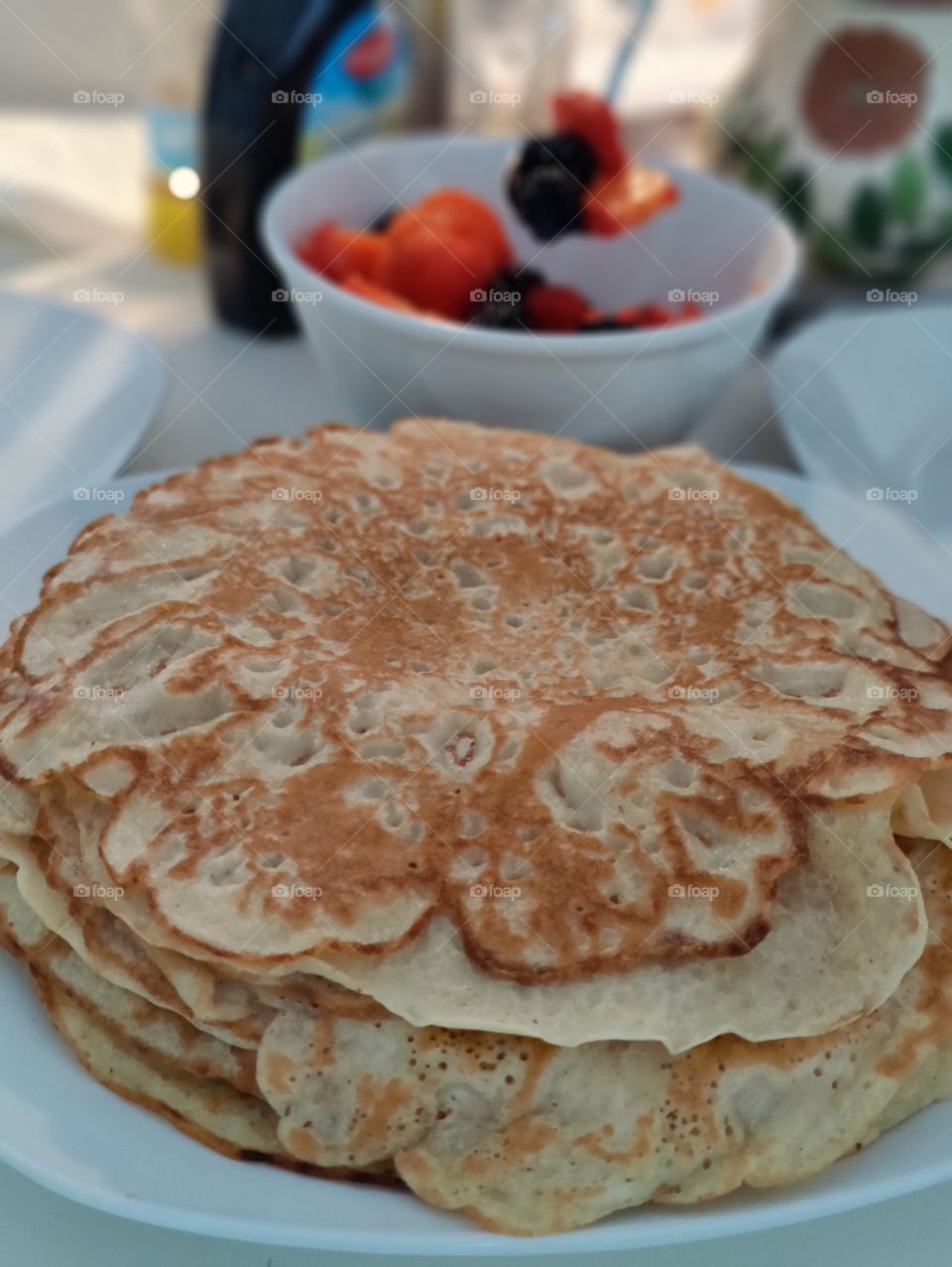 Stack of freshly baked pancakes, ready to be served with fresh fruit