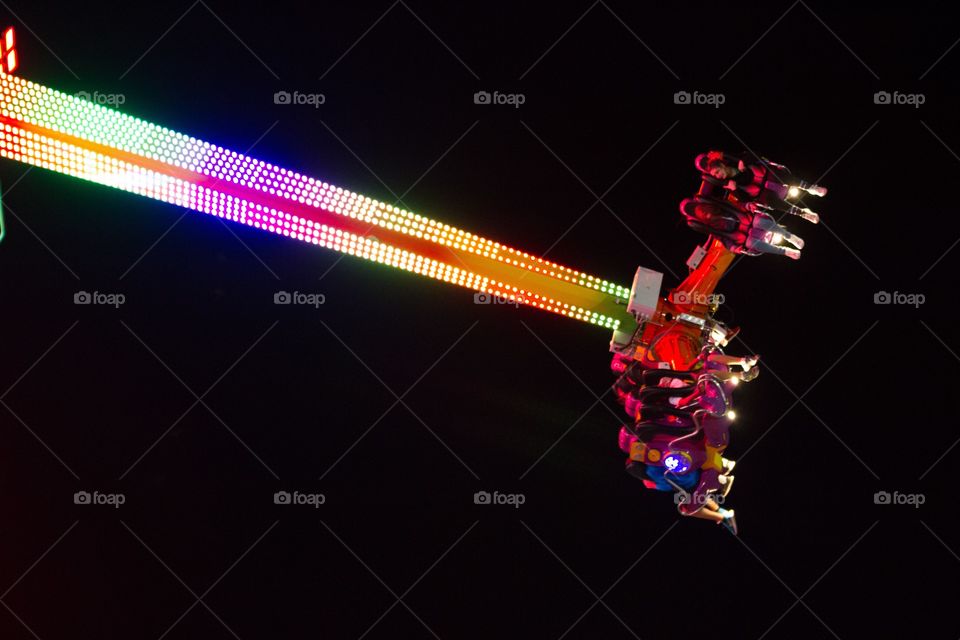 Simple view of long amusement park ride at night lit up