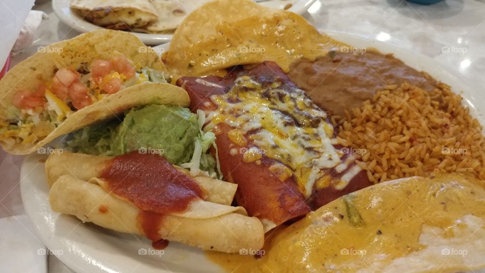 Taco, flaunts, enchiladas, Chile con queso, dinner at the taqueria.  Mexican food.