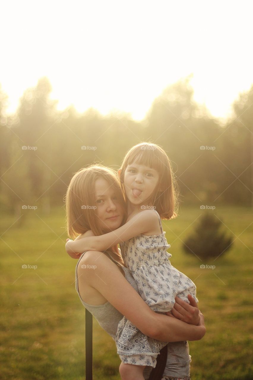 Mom holds a daughter in her arms, which shows the tongue