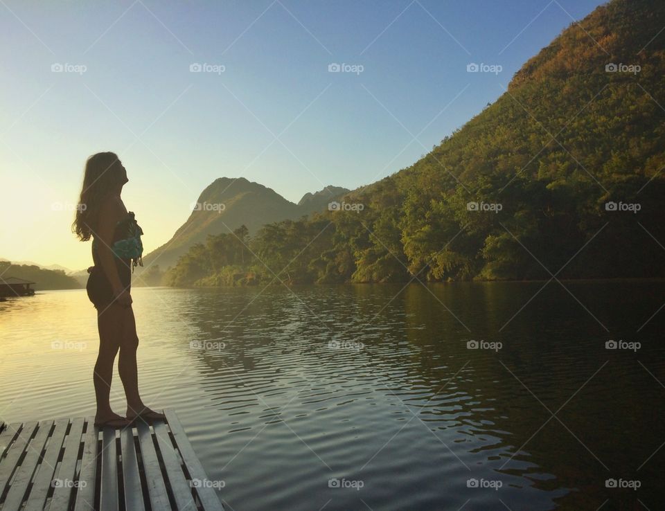 Silhouette woman enjoying peaceful nature at sunrise 