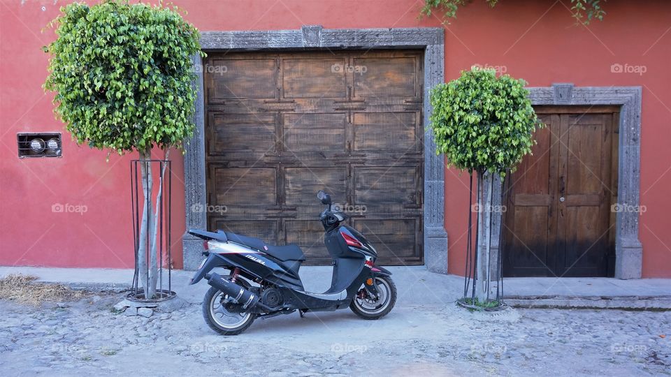Scooter parked near wooden door